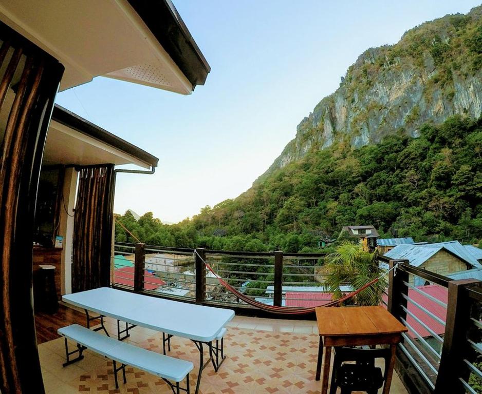 balcón con mesa y vistas a la montaña en Lolo Bob's Bed And Breakfast en El Nido