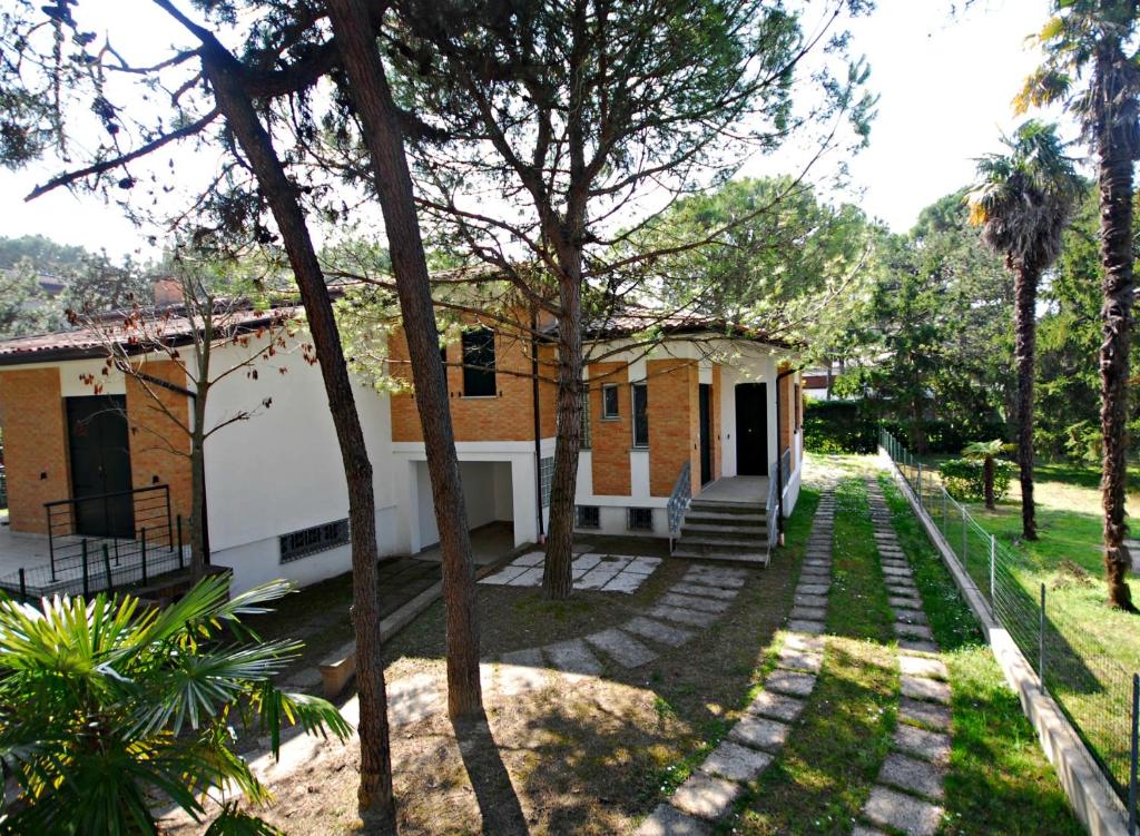 a house with a pathway leading to a yard at Villa Palme in Lignano Sabbiadoro