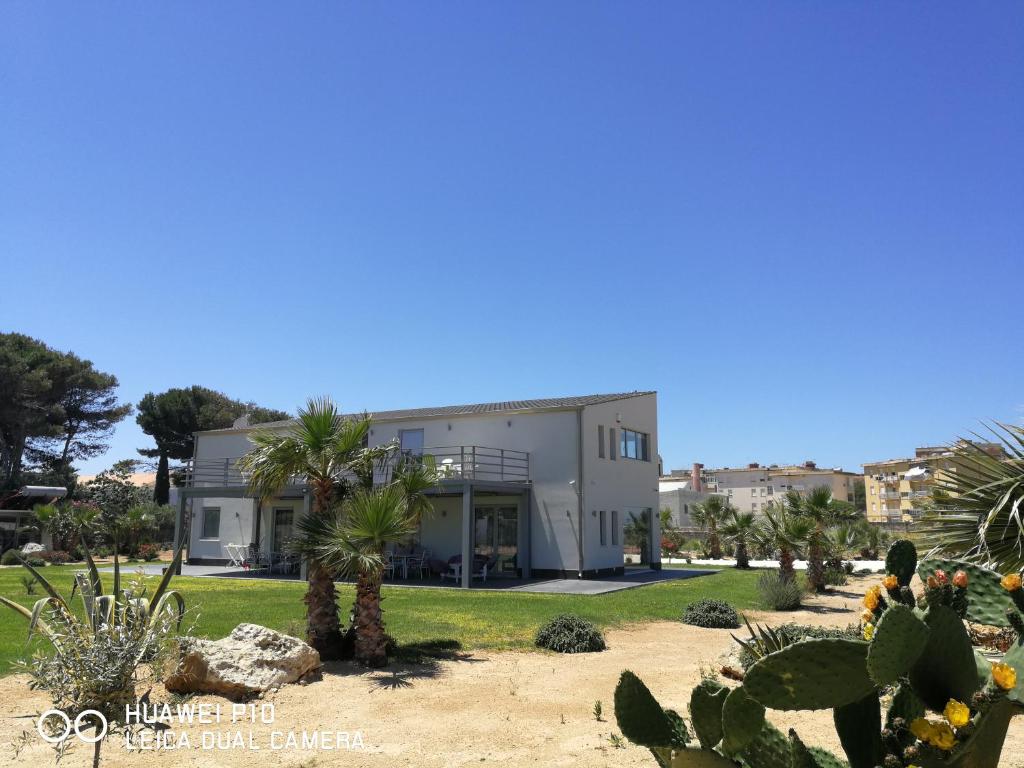 a building with palm trees in front of it at B&B Brezza Delle Egadi in Marsala