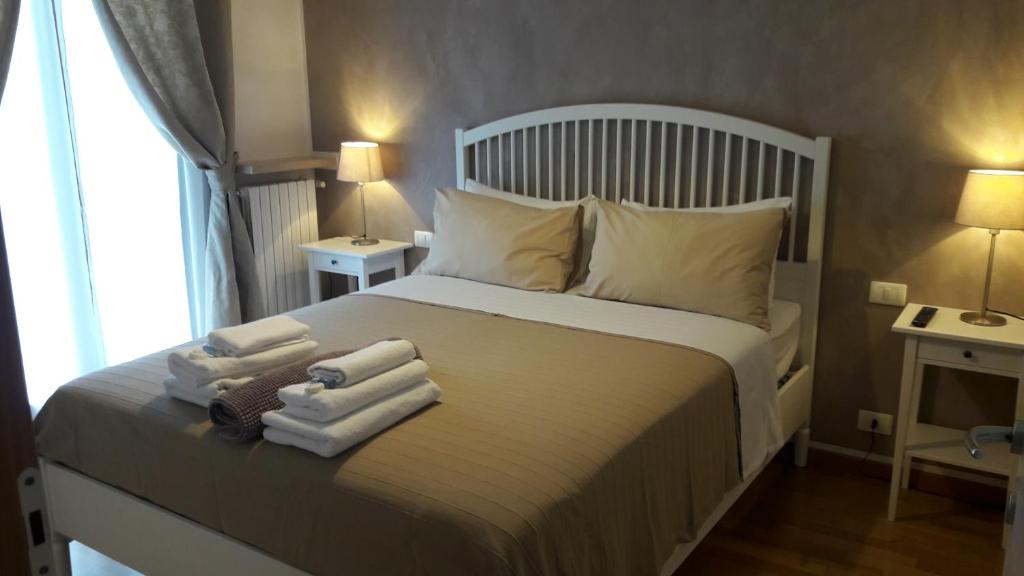 una camera da letto con un letto bianco e asciugamani di Residenza Leon a Castelnuovo del Garda