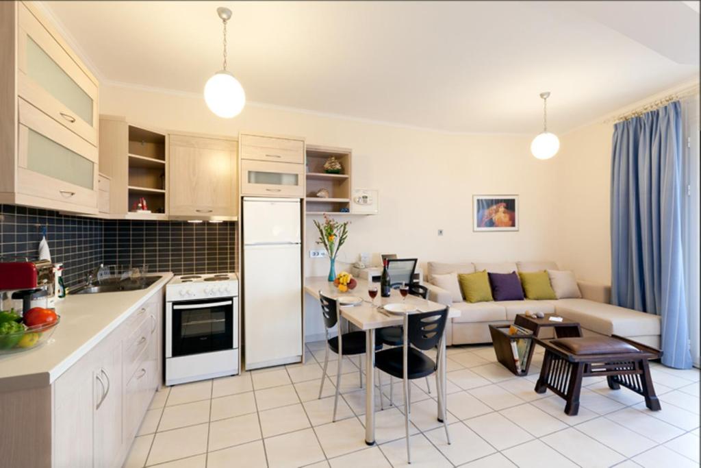 a kitchen and living room with a couch and a table at Giorgi's Blue Apartments in Kalathas