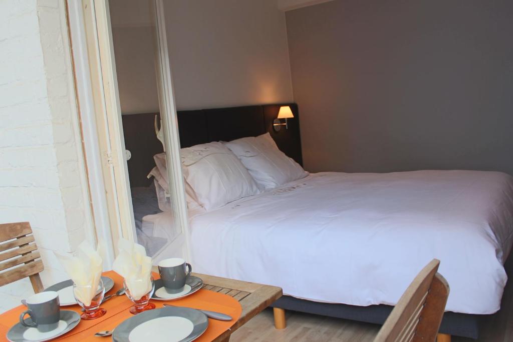 a bedroom with a bed and a table with two plates on it at Appartement Azur Oostende in Ostend