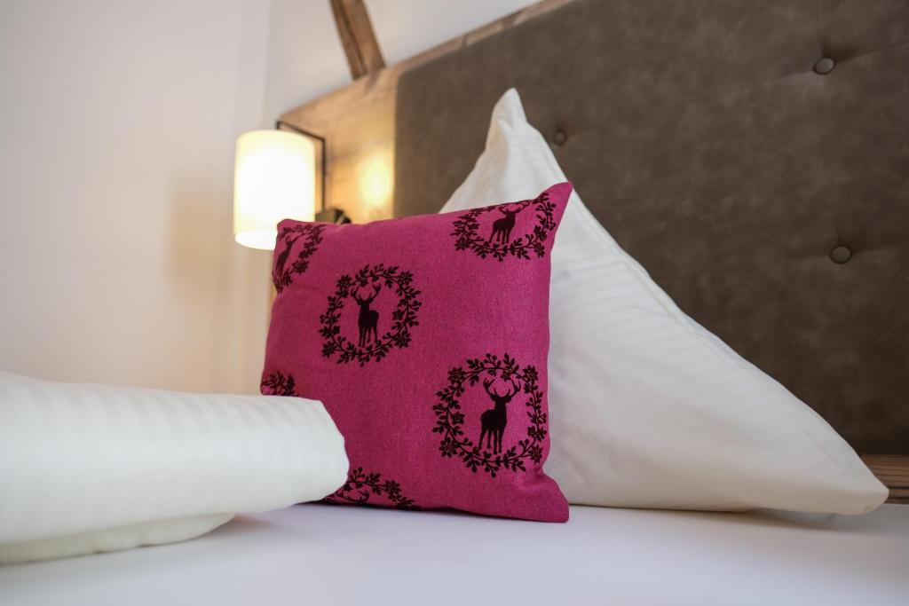 a pink pillow sitting on top of a bed at Alpengasthof zur Post in Schattwald