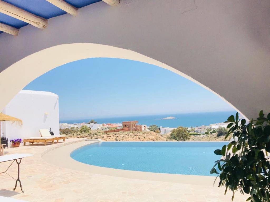 a view of a swimming pool from a house with an arch at CASABAH bed & breakfast in Carboneras