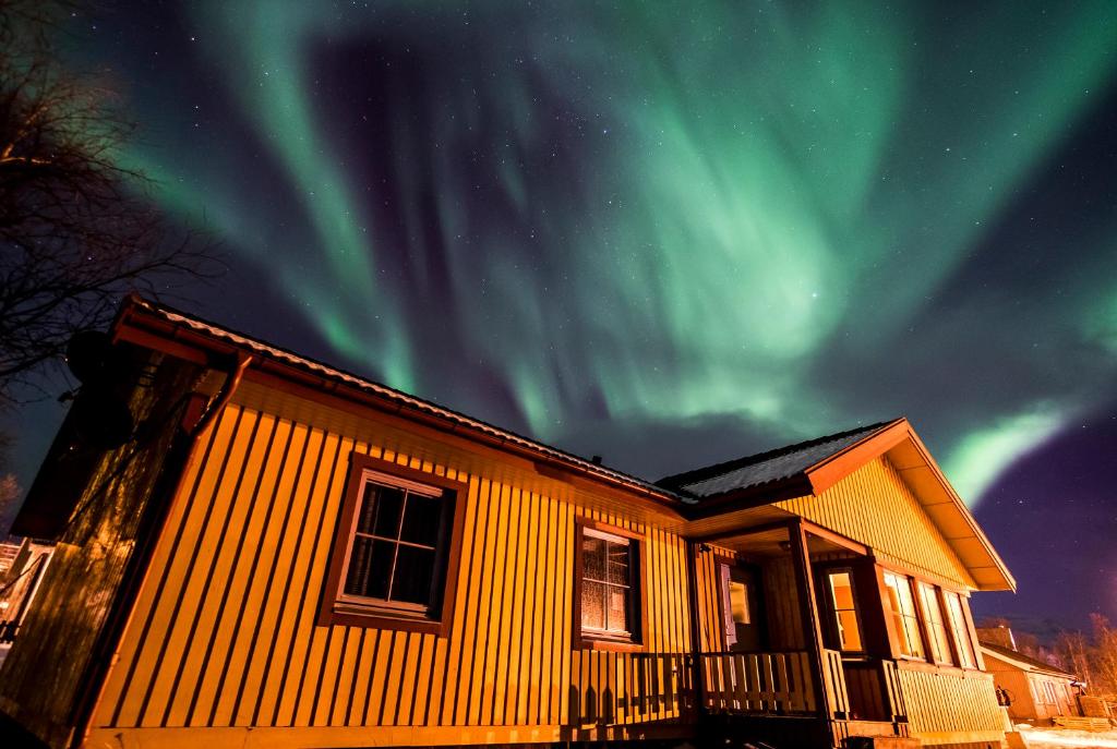 a house with the northern lights in the sky at Lovely house in Abisko in Abisko