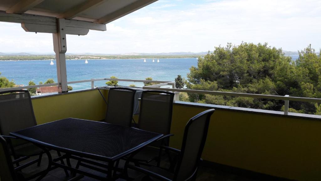 d'une table et de chaises sur un balcon avec vue sur l'eau. dans l'établissement Home Away From Home - Pašman, à Tkon