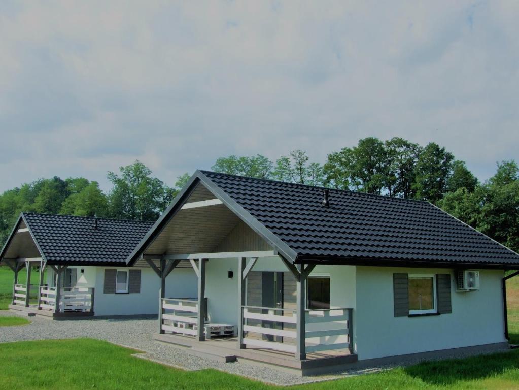 une petite maison avec un toit noir dans l'établissement Domki Komfort całoroczne, à Zator