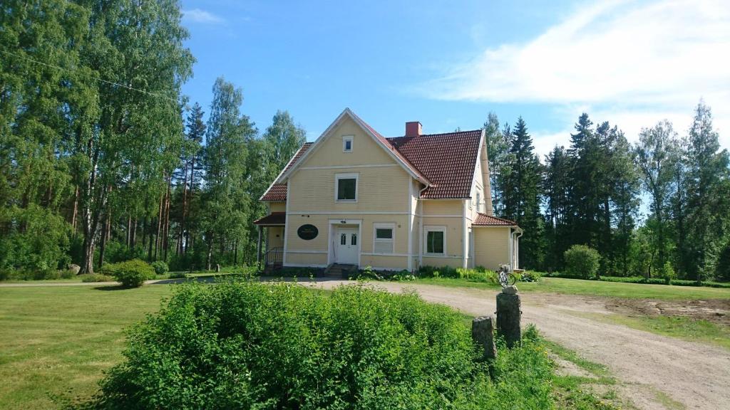 uma casa num campo com uma estrada de terra em Nytorpsgården em Arbrå