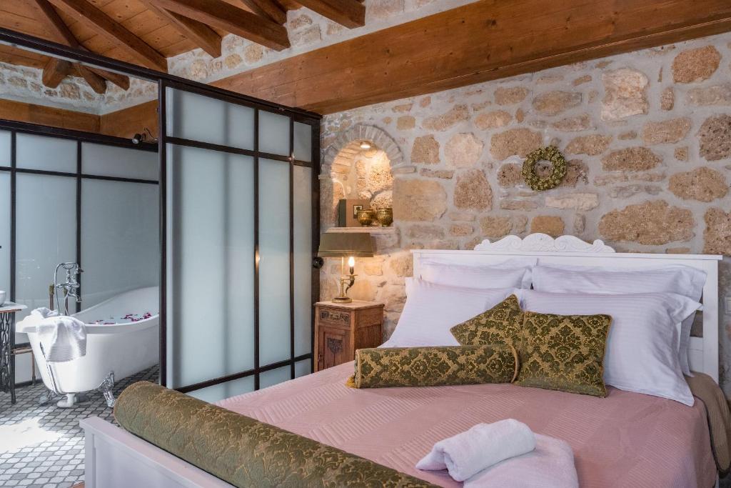 a bedroom with a large bed and a bath tub at Villa Galanoussa in Zakynthos