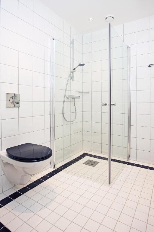 a bathroom with a shower with a toilet and a glass door at Thon Hotel Opera in Oslo