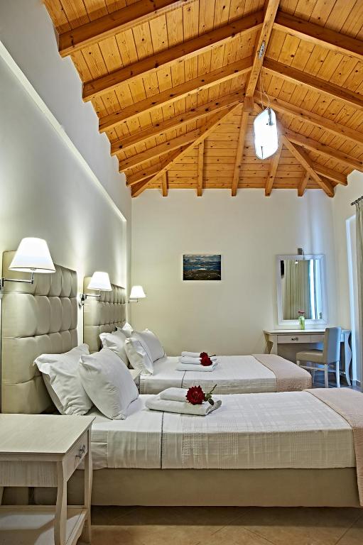 a bedroom with two beds and a wooden ceiling at Element Hotel in Elafonisos