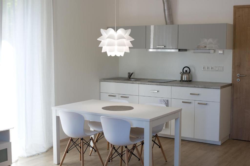 eine weiße Küche mit einem weißen Tisch und Stühlen in der Unterkunft Apartmán SUN Dolní Morava in Dolní Morava
