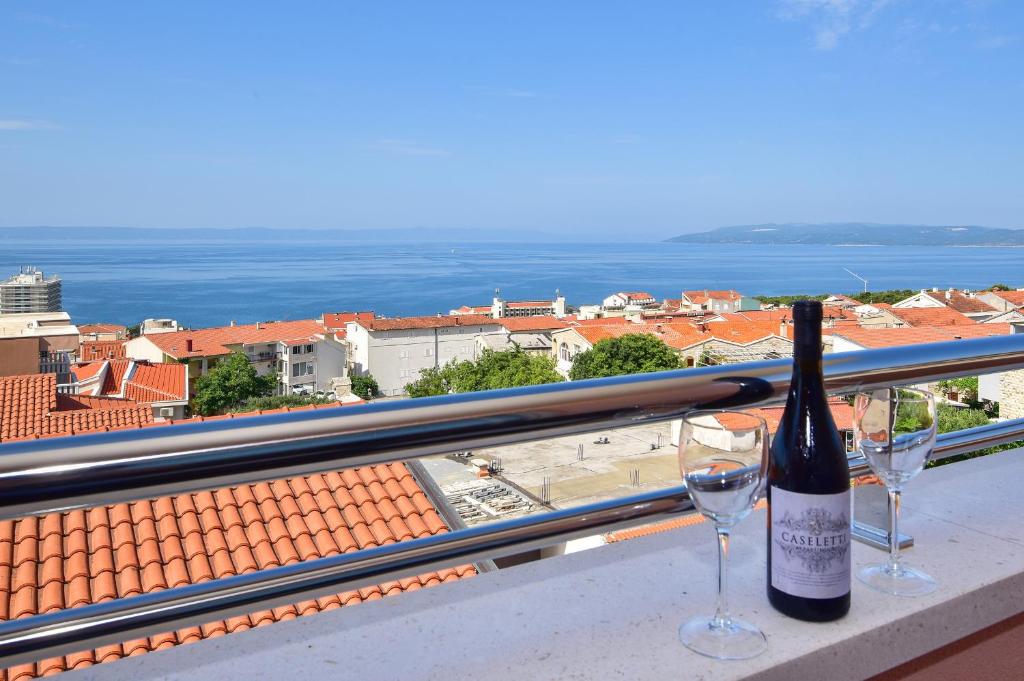 eine Flasche Wein und zwei Gläser auf dem Balkon in der Unterkunft Apartments Evelin in Makarska