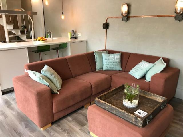 um sofá castanho numa sala de estar com uma mesa em Villa Pats em Gilze
