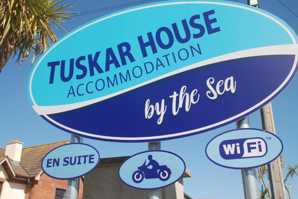 ein Schild für einen Tulsar-Hausverband und ein Motorrad in der Unterkunft Tuskar House by the Sea in Rosslare