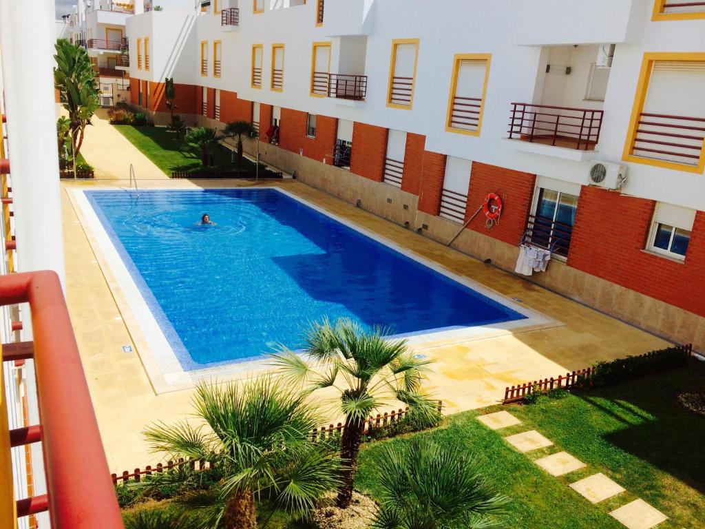 a person swimming in a swimming pool next to a building at Luxury Duplex with pool in Cabanas de Tavira