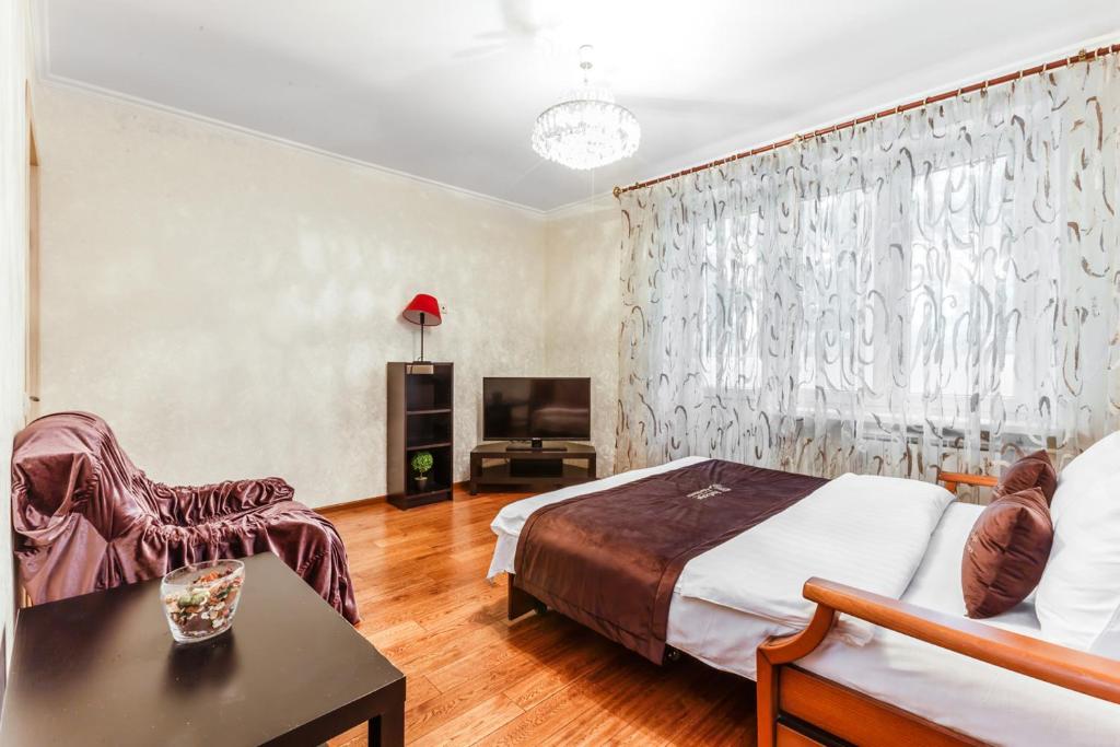 モスクワにあるInnDays on Garibaldiのベッドルーム(ベッド1台、テーブル、テレビ付)