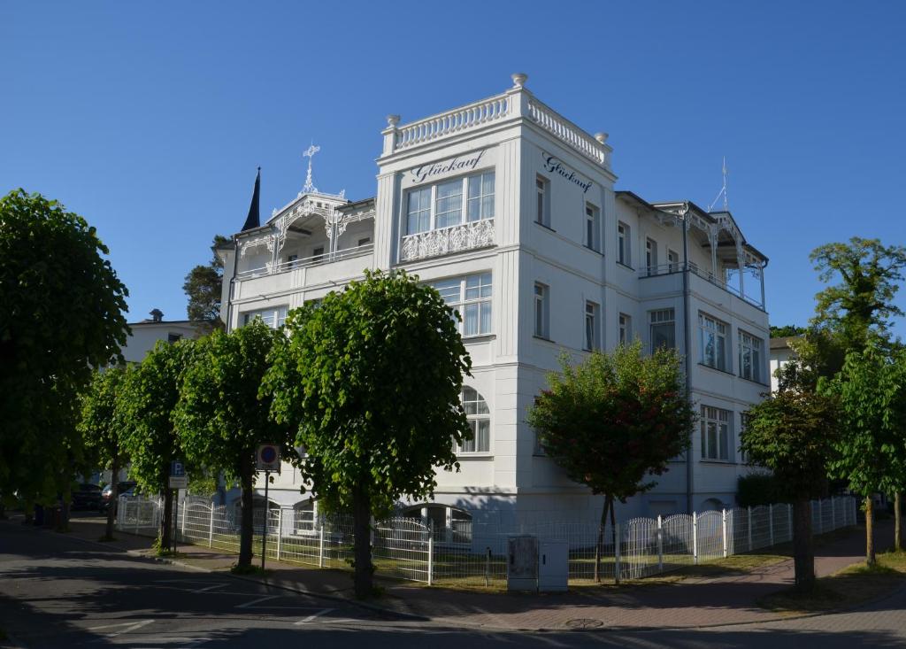 un edificio blanco con árboles delante de él en Strandvilla Glückauf, en Binz