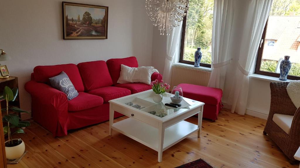 a living room with a red couch and a coffee table at Schnucken-Hus in Amelinghausen