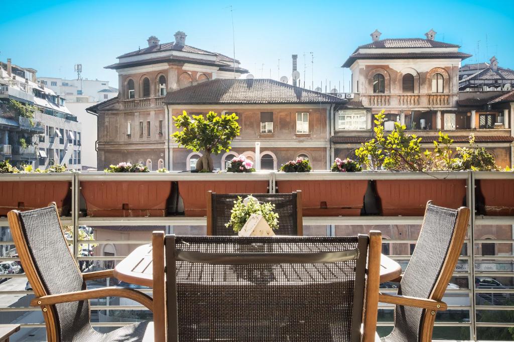 een tafel en stoelen op een balkon met een gebouw bij Boutique Domus River Terrace in Rome
