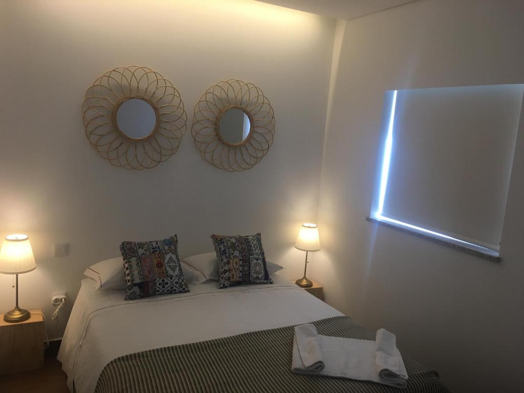 a bedroom with a bed and two mirrors on the wall at Casa do Peso 2 in Peso da Régua