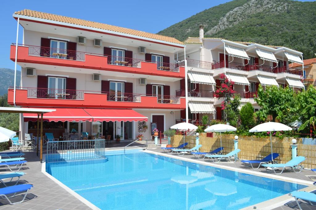 a hotel with a swimming pool in front of a building at Sunrise Studios in Nydri