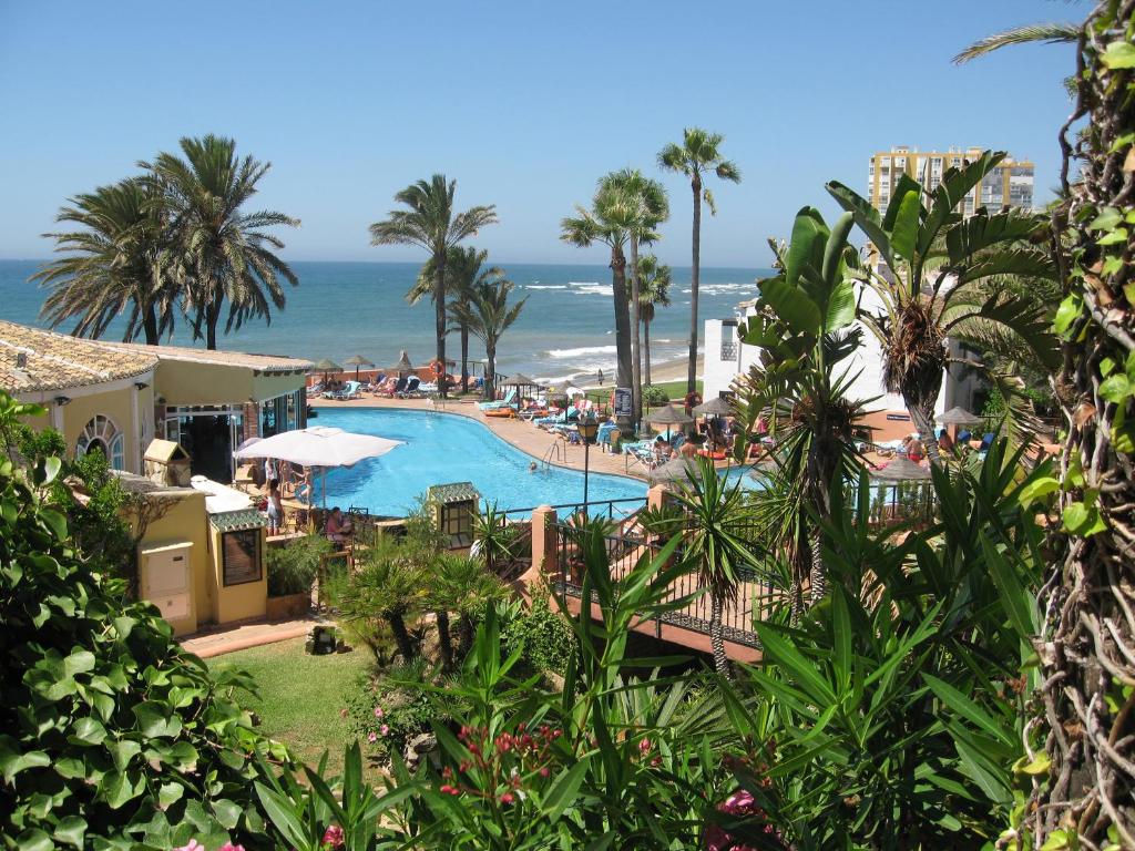 a view of a resort with a swimming pool and the ocean at Macdonald Doña Lola Resort in La Cala de Mijas