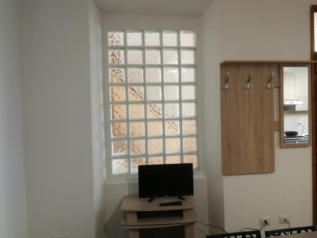 a living room with a television and a window at Valery Apartments Alghero in Alghero