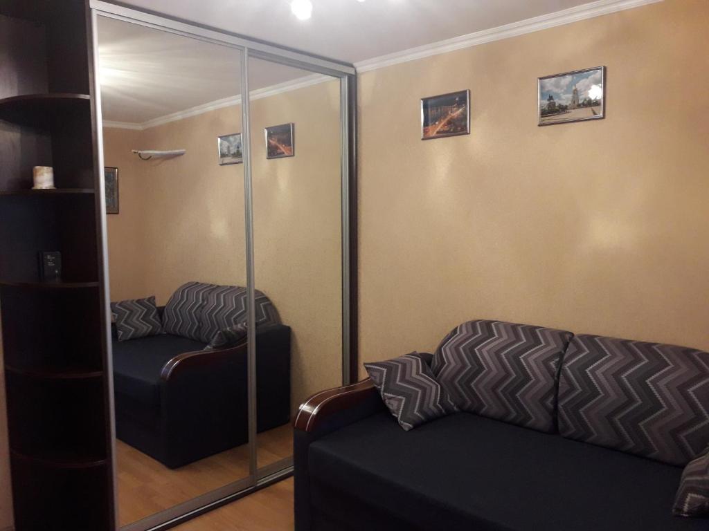 a living room with a mirror and a couch at ApartamentKievVinogradar in Kyiv