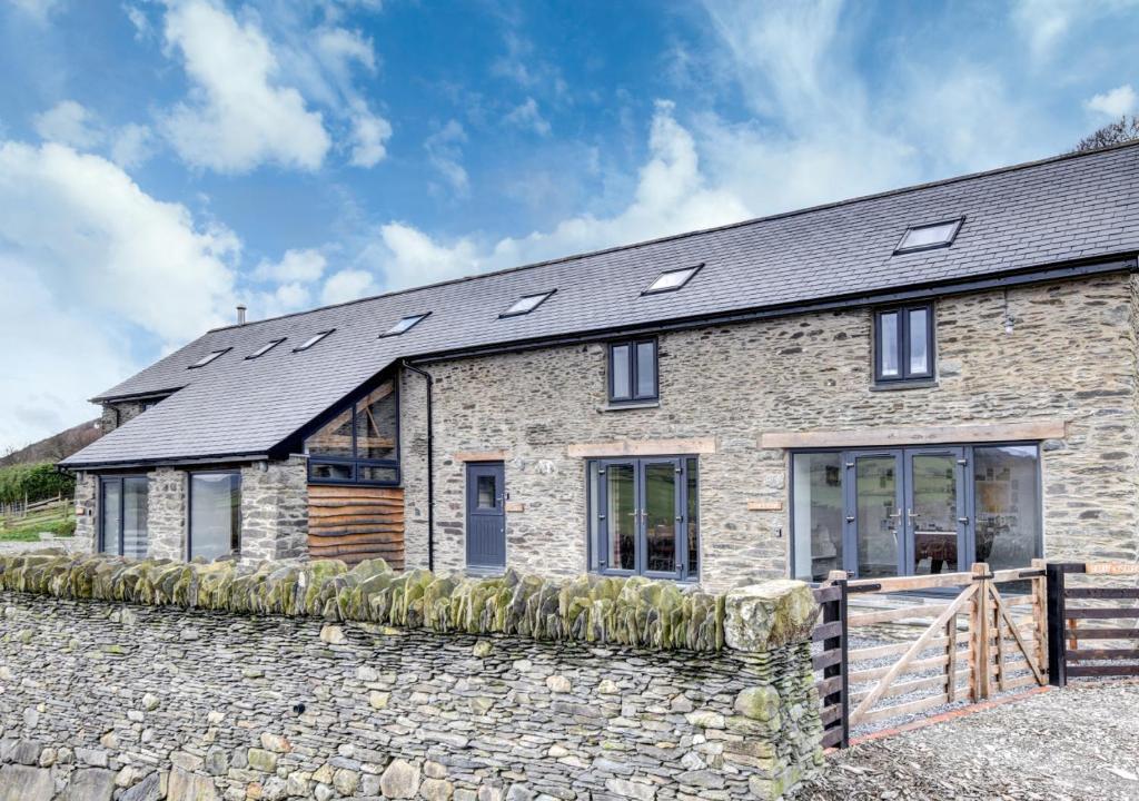 een stenen huis met zonnepanelen op het dak bij 2 Bed in Machynlleth oc-bow39 in Darowen