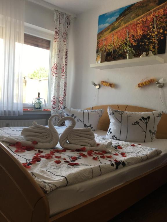 two swans are sitting on a bed with flowers at Pension "Am Markt" in Treis-Karden