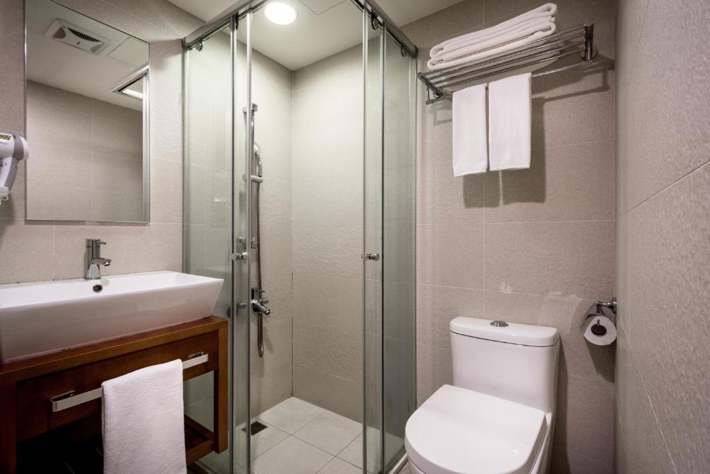 a bathroom with a shower and a toilet and a sink at Wemeet Hotel Taipei in Taipei