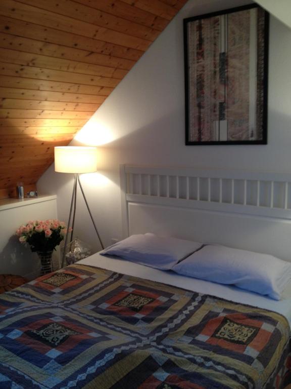 a bedroom with a bed with a quilt and a lamp at Executive suite in Zug Old Town Triplex in Zug