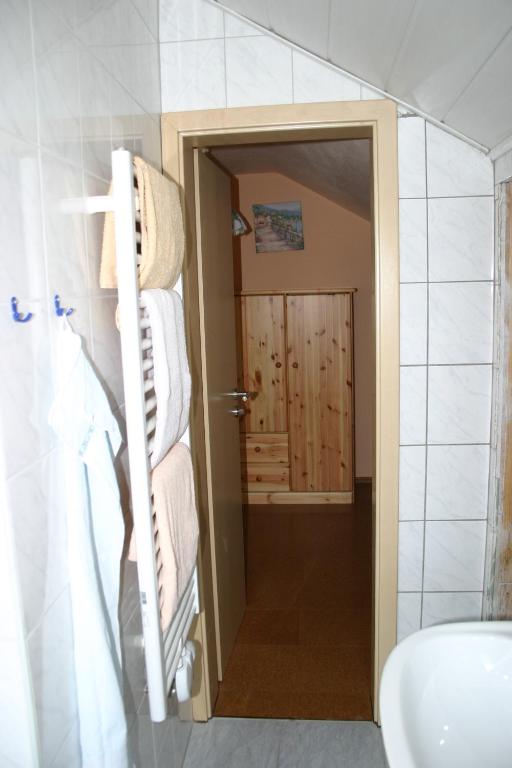 a bathroom with a sink and a door with towels at Gasthof Zum Stausee in Engelskirchen