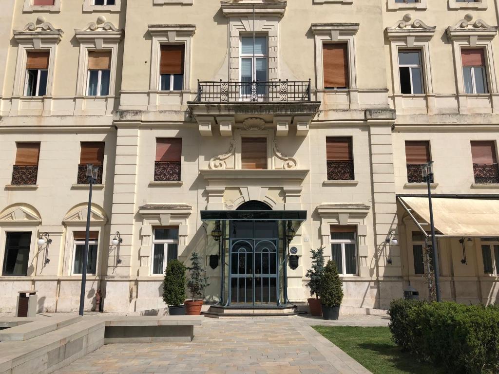 un grande edificio bianco con una porta e un balcone di Grande Albergo Quattro Stagioni a Rieti