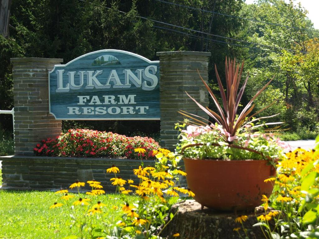 a sign for the lukens farm resort with flowers at Lukans Farm Resort in Hawley