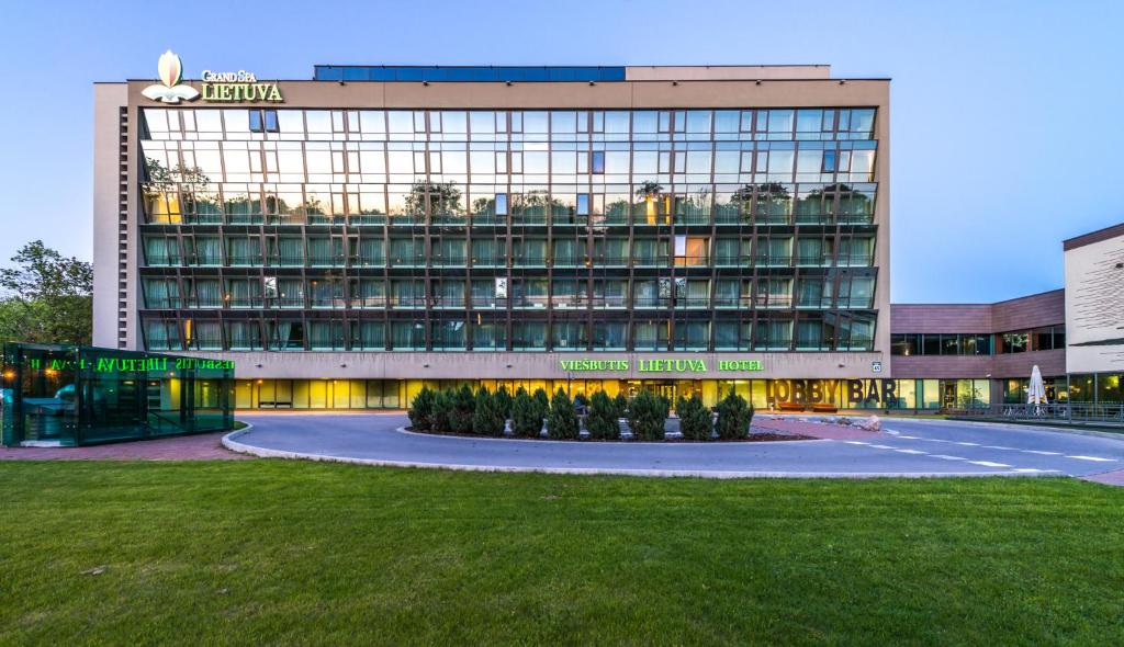 a large building with a lawn in front of it at Grand SPA Lietuva Hotel Lietuva in Druskininkai