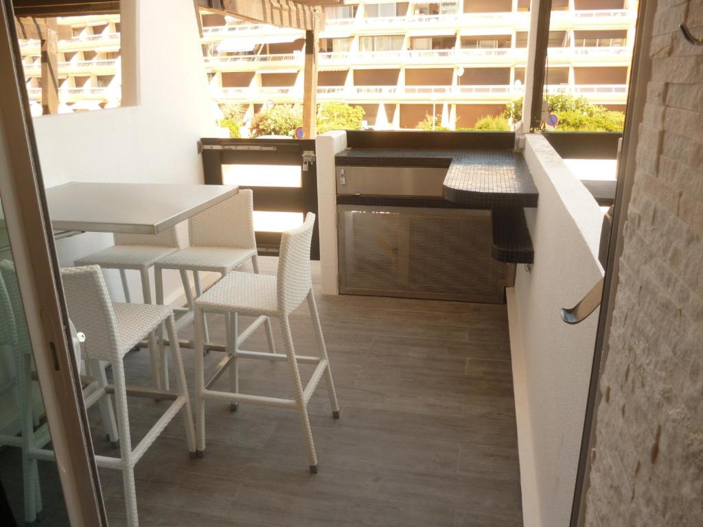 uma cozinha com mesa e cadeiras e uma varanda em AphrodiX em Cap d'Agde