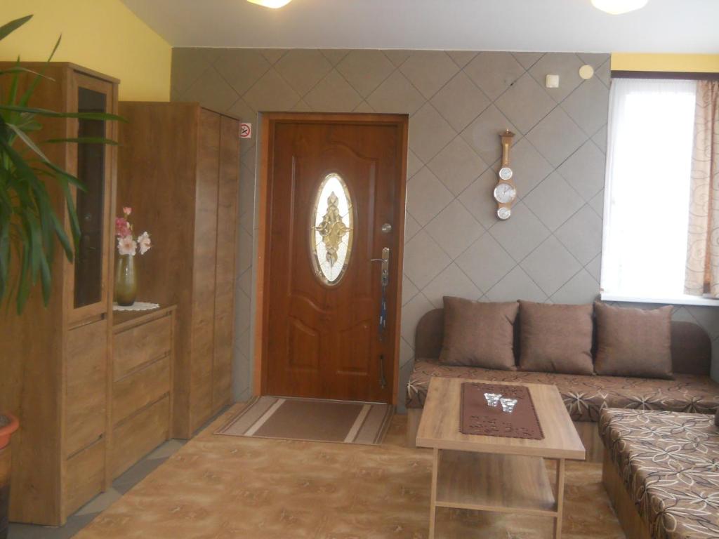 salon z kanapą i drewnianymi drzwiami w obiekcie U Derca w mieście Gnieżdżewo