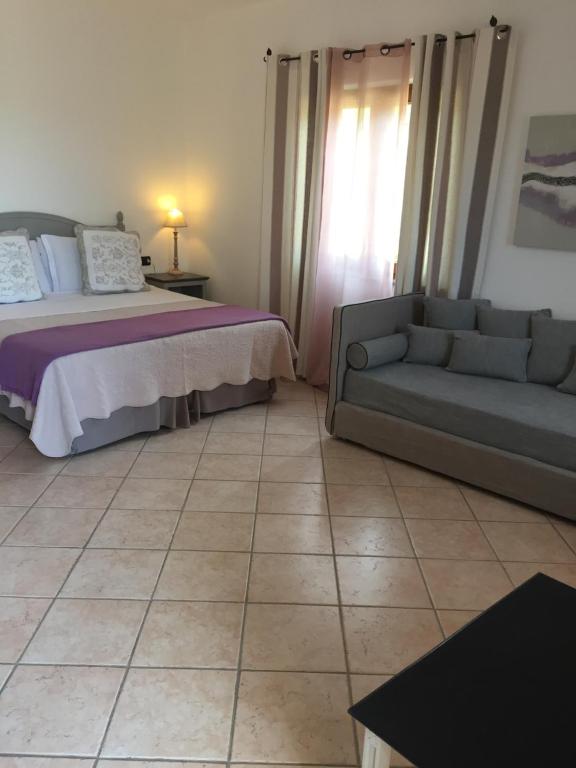 a living room with a bed and a couch at Relais Fenicottero Rosa in Porto San Paolo