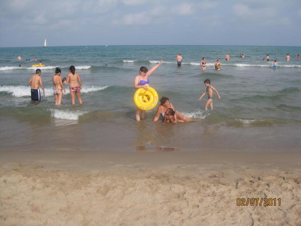 a group of people playing with a frisbee on the beach at Burriana in Burriana