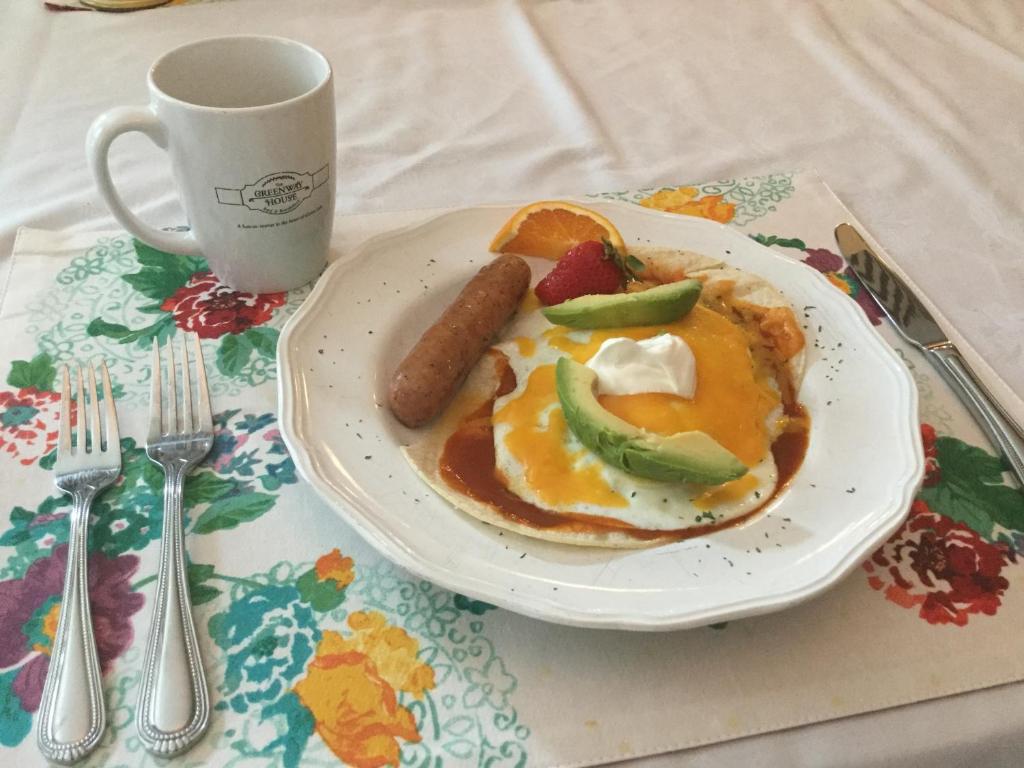 a plate of food with sausage and a cup of coffee at Greenway House Bed and Breakfast in Green Lake