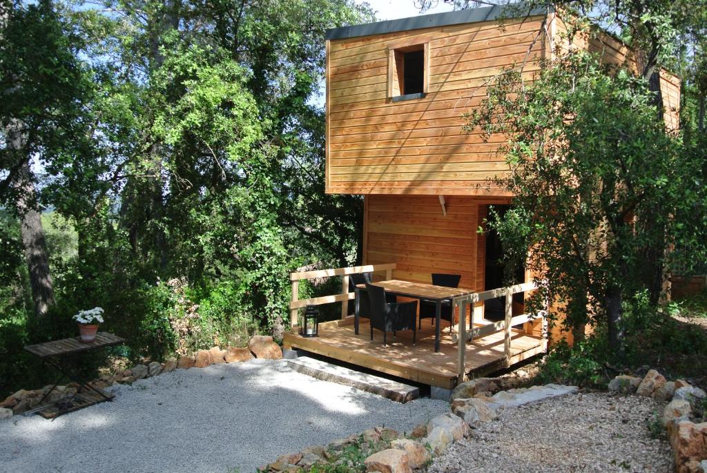 een houten hut met een tafel ervoor bij LA MAISON DES "BOIS" in Lorgues