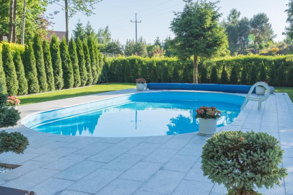 a swimming pool in a yard with trees and bushes at Dom na Kaszubach - Lewinko in Lewinko