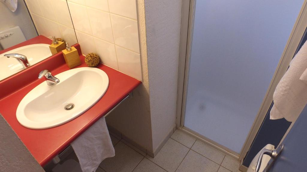 a bathroom with a sink and a red counter at VVF Sud Vercors in Die