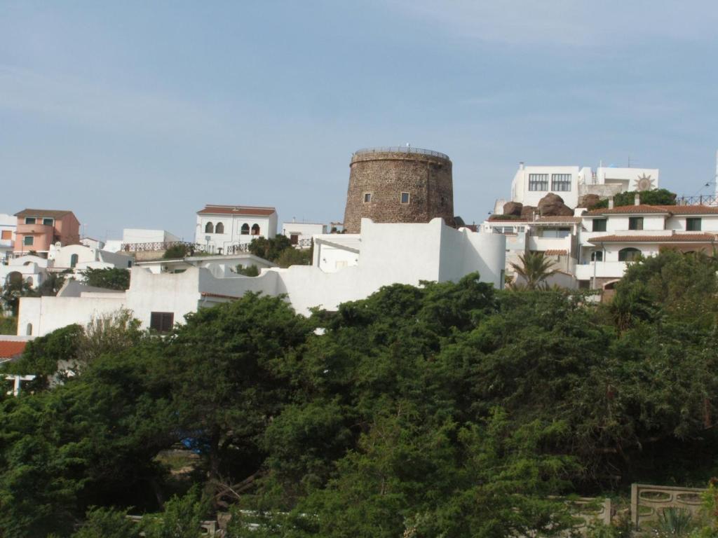 a group of buildings on a hill with trees at Una Finestra sul Mare in Calasetta