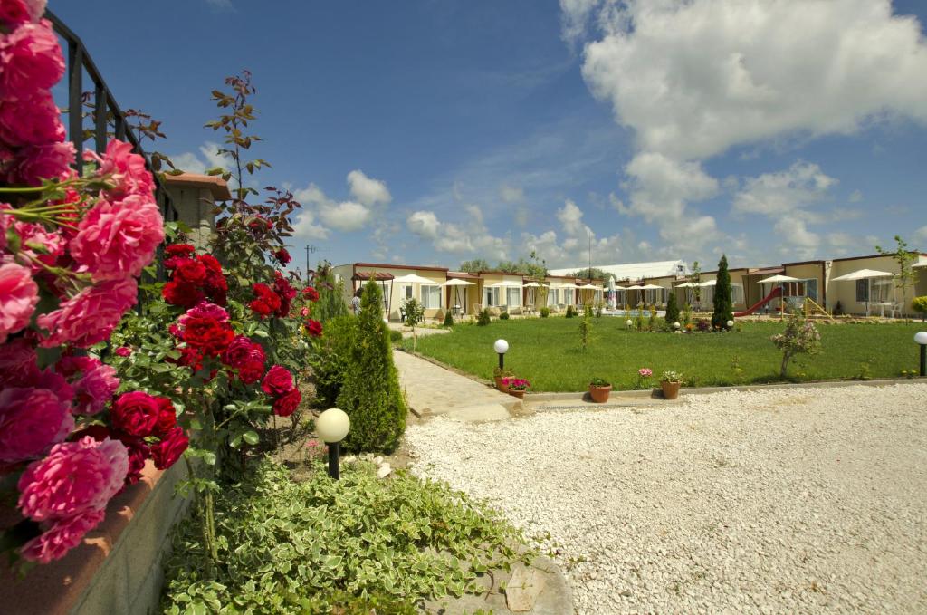 a garden with flowers and houses in the background at Di Mare Holiday Village in Kranevo