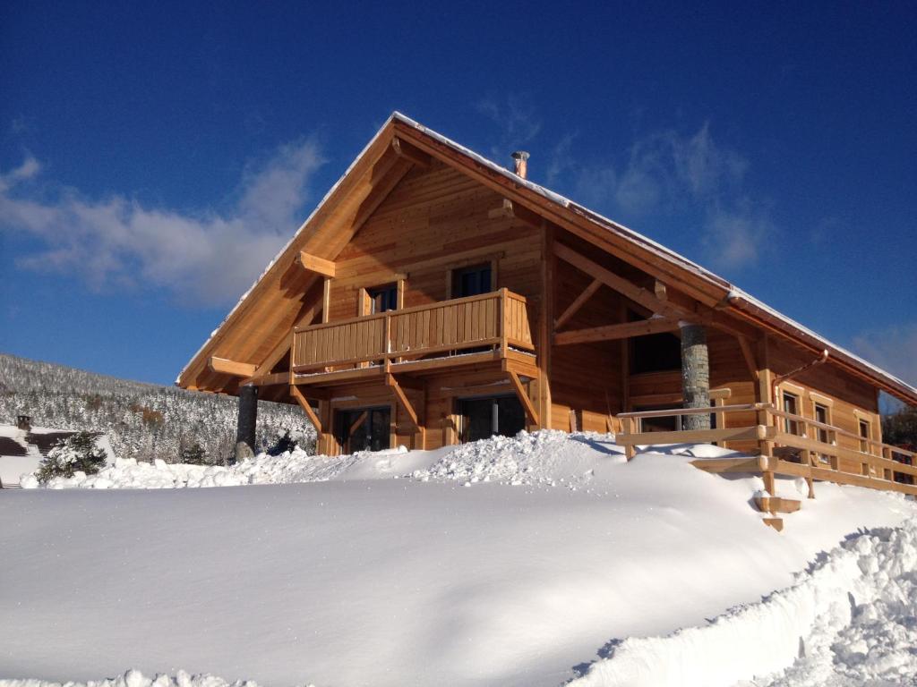una cabaña de madera en la nieve con nieve en Au cœur du bois en Le Bouilly