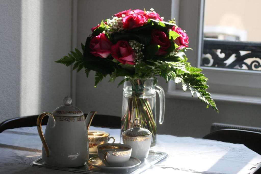 Appartement 3 pièces, Krutenau, Parking privé في ستراسبورغ: مزهرية من الزهور تجلس على طاولة مع أكواب