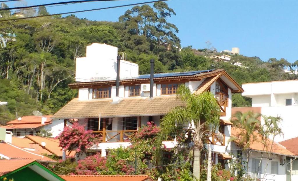 una casa con una montaña en el fondo en Apartamentos Morada Aquitânia, en Bombinhas